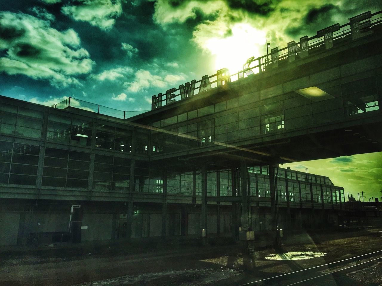 architecture, built structure, building exterior, sky, cloud - sky, cloudy, dusk, cloud, city, transportation, weather, building, outdoors, railroad track, factory, industry, no people, sunset, overcast, connection