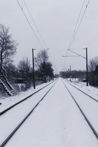 Snow covered railroad tracks against sky