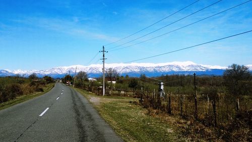 Road leading towards mountains against sky