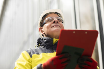 Male entrepreneur looking away while holding clipboard