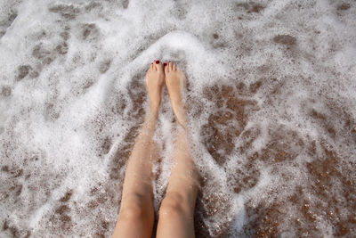Travel concept - woman's legs on beautiful tropical beach with pebble sand. feet on sand 