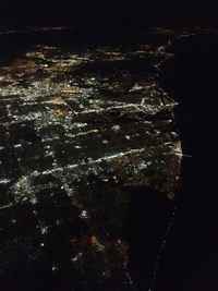 High angle view of illuminated cityscape against sky at night