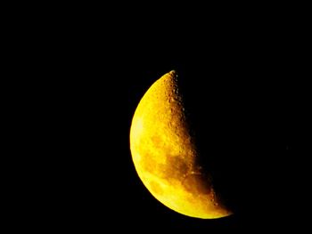 Low angle view of yellow moon against sky at night