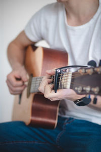 Midsection of man playing guitar