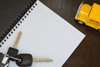 Directly above shot of car key with book on table