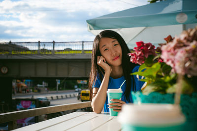 Portrait of woman having coffee while sitting at outdoor cafe
