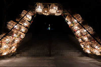 Low angle view of illuminated lights hanging from ceiling in building