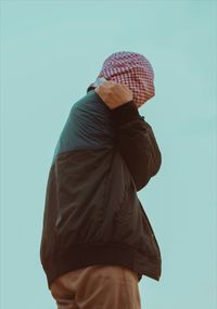 Rear view of man standing against blue background