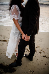 Rear view of couple standing at beach