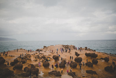 People standing on beach against sky