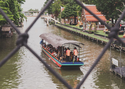 People on boat in river against trees