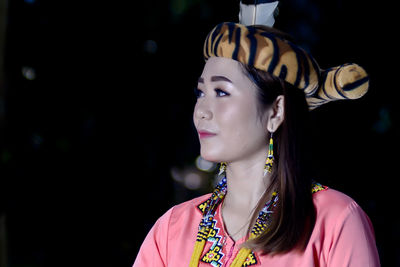 Close-up of young woman looking away standing outdoors