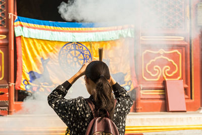 Rear view of woman standing against graffiti