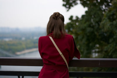 Rear view of woman standing at railing