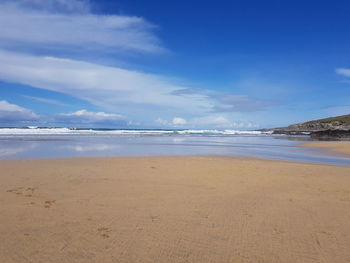 Scenic view of beach against blue sky