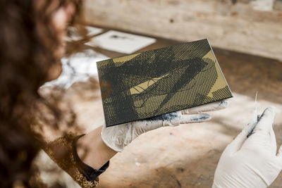 Female artist inspecting a plate and preparing it for a handmade