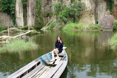 Woman sitting on boat in river