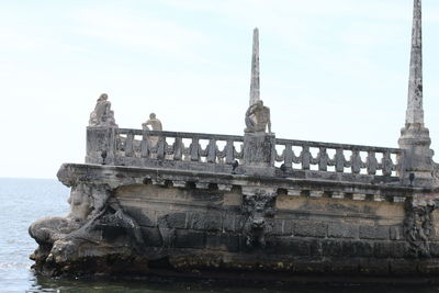 View of old bridge over sea against sky