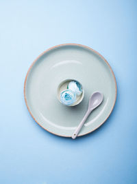 Directly above shot of blue container on table against white background