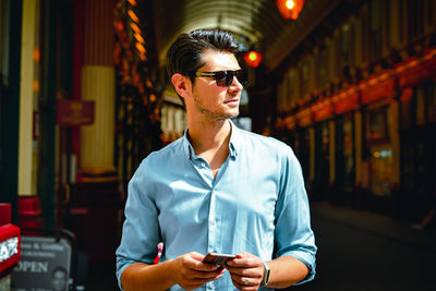 Full length of young man wearing sunglasses standing outdoors