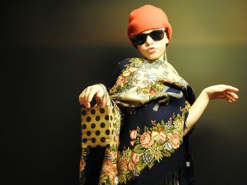 Portrait of girl sunglasses standing against wall