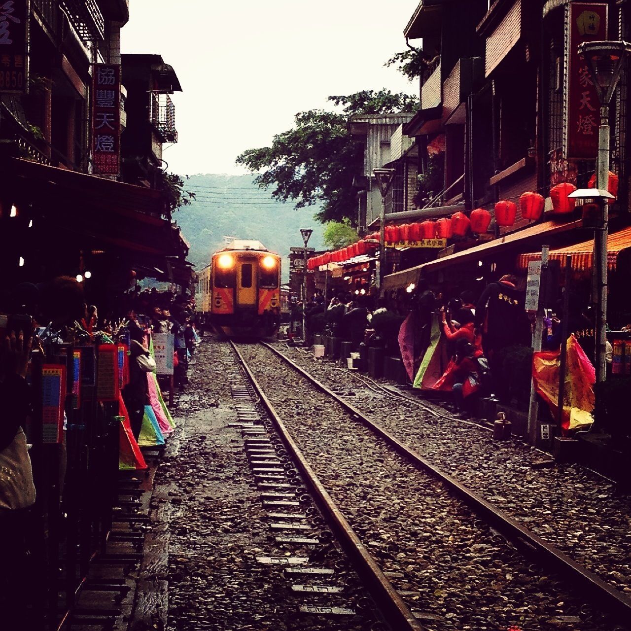 railroad track, building exterior, architecture, built structure, transportation, rail transportation, city, public transportation, men, city life, person, large group of people, diminishing perspective, incidental people, lifestyles, high angle view, the way forward, outdoors, day