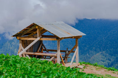 Traditional windmill on field against sky