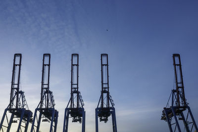 Low angle view of cranes against sky