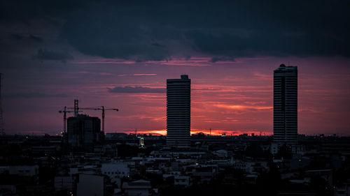 View of cityscape against cloudy sky during sunset