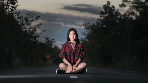 Portrait of woman sitting on road