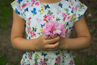 Midsection of woman holding purple flowering plants