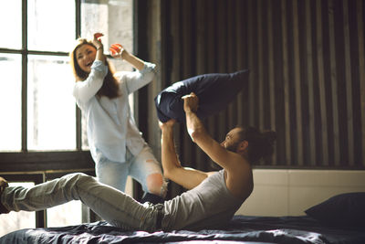 Young pretty couple having fun on bed in morning.