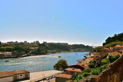 High angle view of city by river against clear sky