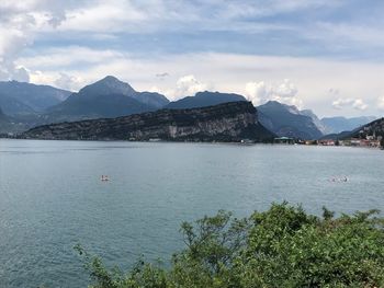 Scenic view of sea by mountains against sky