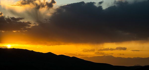 Scenic view of silhouette mountains against sky during sunset