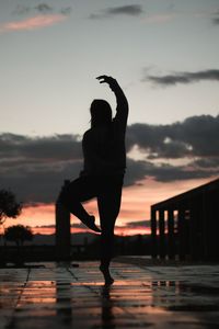 Silhouette woman exercising against sky during sunset