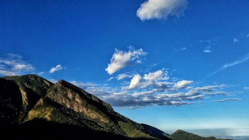 Low angle view of mountain range against cloudy sky