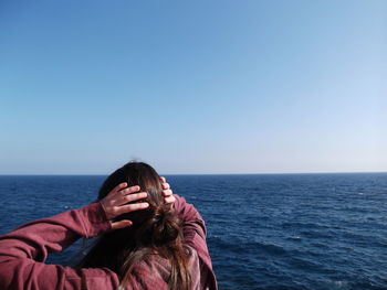 Woman in sea against clear sky