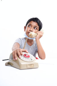 Portrait of boy holding ice cream against white background