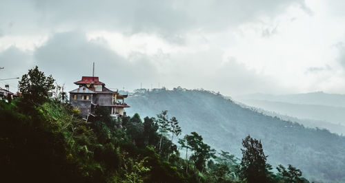 Panoramic view of trees and buildings against sky