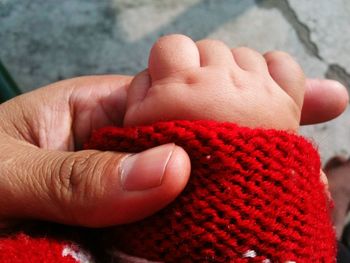 Cropped person and baby holding hands