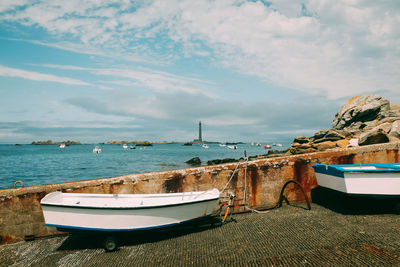 Sailboats moored on sea against sky