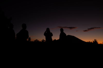 Silhouette people against sky at sunset