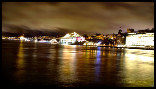 Illuminated buildings against sky at night