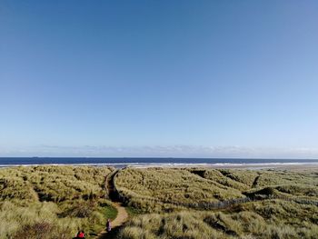 Scenic view of beach against clear blue sky
