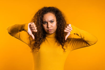 Portrait of woman with yellow hair against orange background