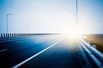 Road leading towards city street against sky