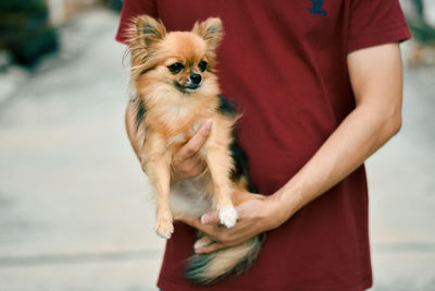 Man holding dog standing outdoors