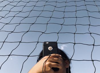 Low angle view of person photographing through mobile phone
