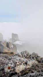 Scenic view of castle ruins surrounded by clouds against sky